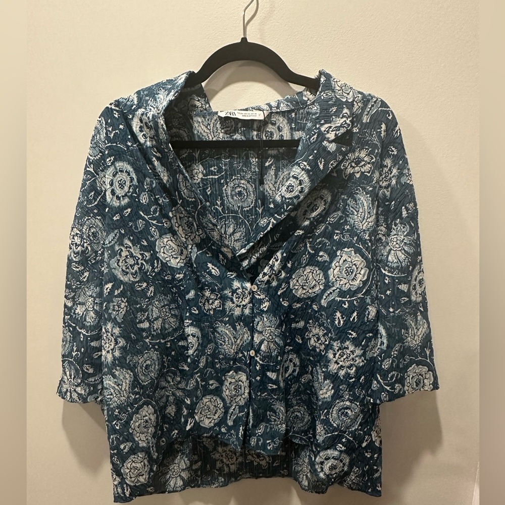 FLOWY V-NECK SHIRT WITH LAPEL COLLAR AND SHORT SLEEVES. FRONT BUTTON CLOSURE.